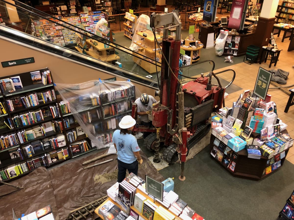 The Mini-Mole track rig drilling inside an occupied retail interior.