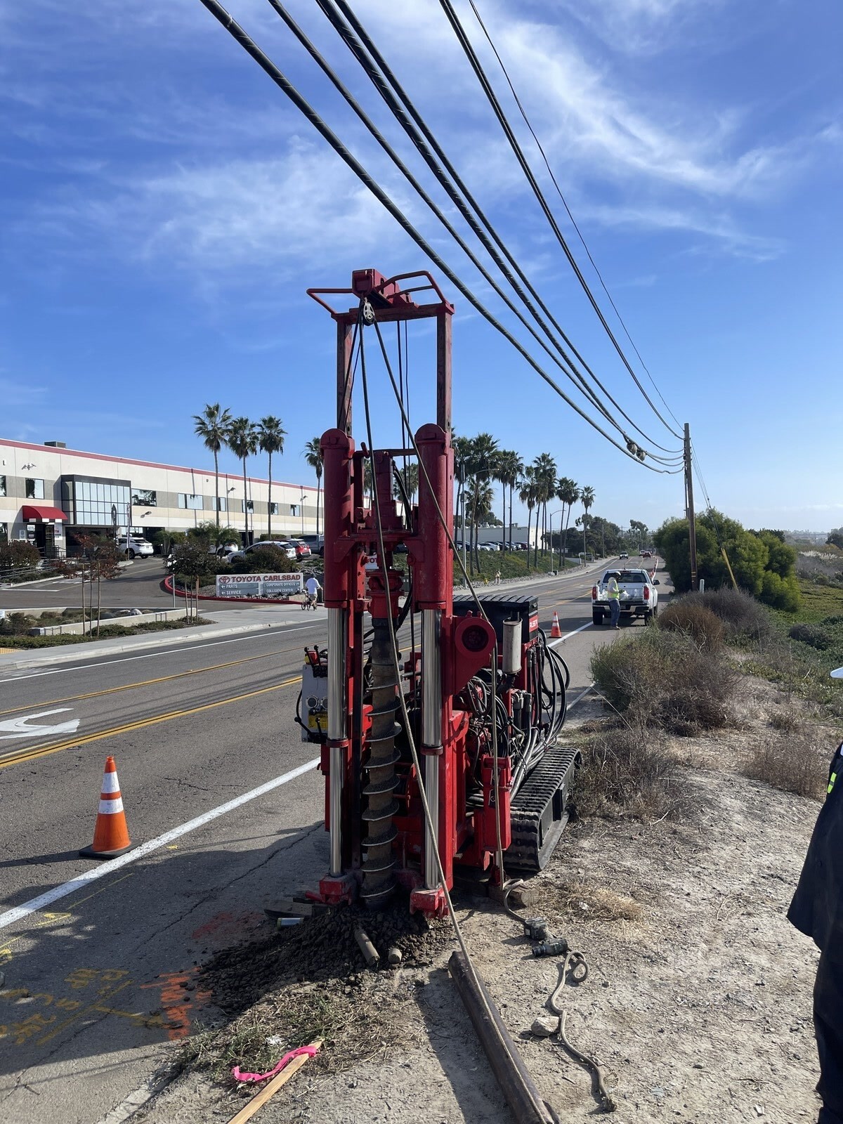 The Mole low-overhead track rig working at a roadside beneath power lines.