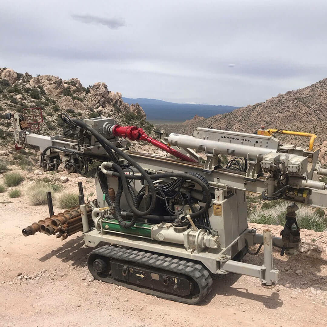 The Fraste PL-G track rig standing on open desert ground below a ridge.